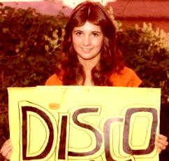 70s-looking photo of a girl holdign a hand-made sign that reads 'disco'